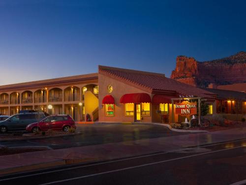 ein Hotel mit auf einem Parkplatz geparkten Autos in der Unterkunft Desert Quail Inn Sedona at Bell Rock in Sedona