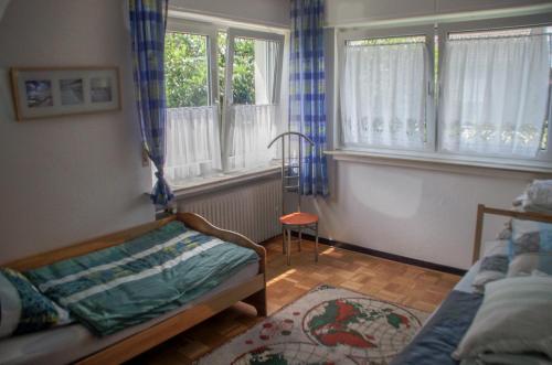 - un salon avec un lit et des fenêtres dans l'établissement Linnemanns Gaestehaus, à Lippetal