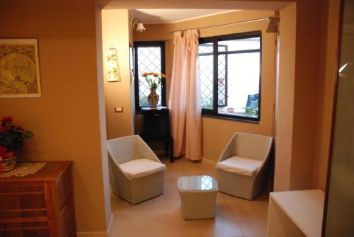 a living room with two chairs and a window at Garden on the Sea in Vico Equense