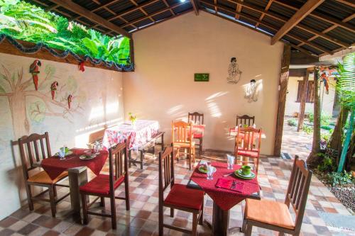 un comedor con mesas y sillas y un mural en Pousada Aloes, en Paraty