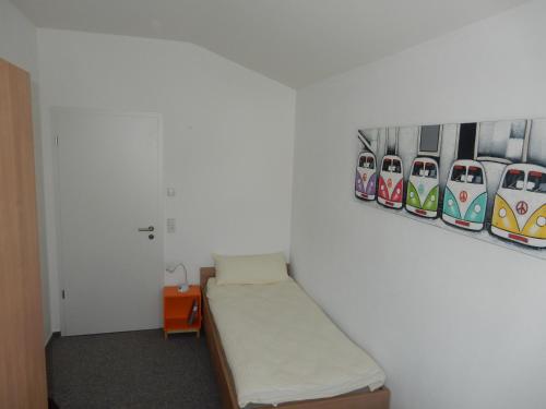 Habitación con cama y pinturas en la pared. en Beim Kellerschneider OG, en Gundelfingen