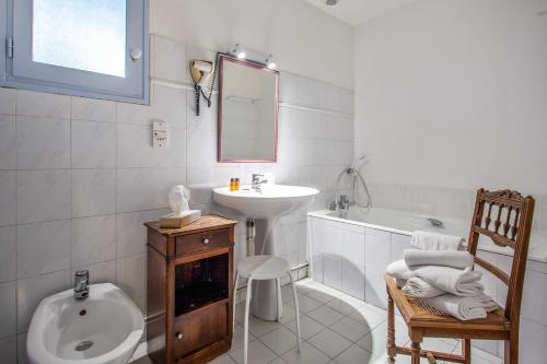 y baño blanco con lavabo y bañera. en La Ferme de Thoudiere, en Saint-Étienne-de-Saint-Geoirs