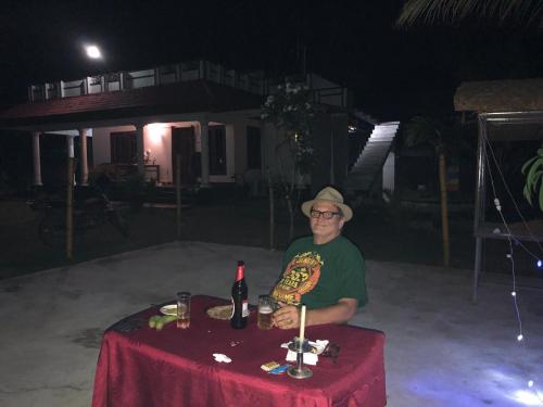 a man sitting at a table with a bottle of wine at Angels' homestay Marari in Mararikulam