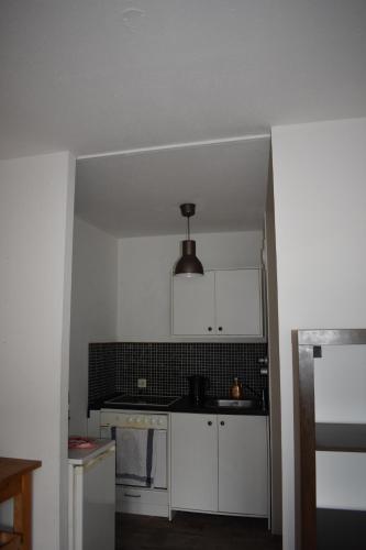 an empty kitchen with white cabinets and a ceiling at FeWo Köln in Cologne
