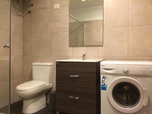a bathroom with a toilet and a washing machine at Finca Casa Grande in Tavernes de Valldigna