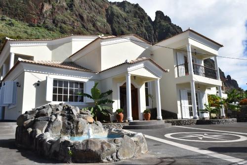 a white house in front of a mountain at Mansion Almond - SEA, SUN and a charming refuge! in Paul do Mar