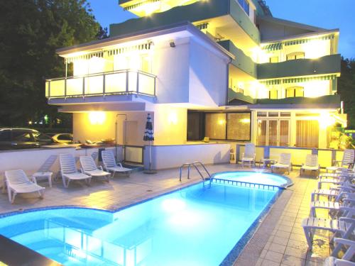 una casa con piscina y un edificio en Hotel Oasi, en Lignano Sabbiadoro