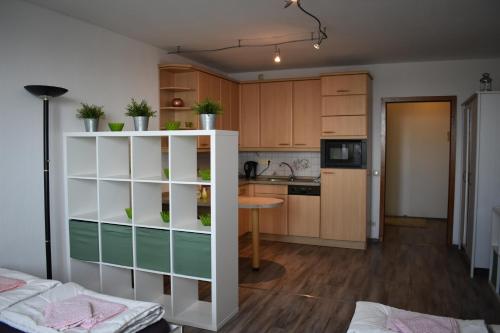 een keuken met houten kasten en een tafel in een kamer bij FeWo Köln in Keulen