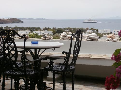 a table and chairs on a balcony with a view of the ocean at Galini Bungalows in Kionia