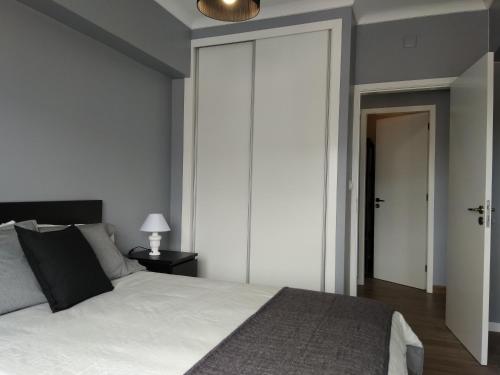 ポンタ・デルガダにあるCantinho do Céuのベッドルーム1室(白いベッド1台、スライドドア付)