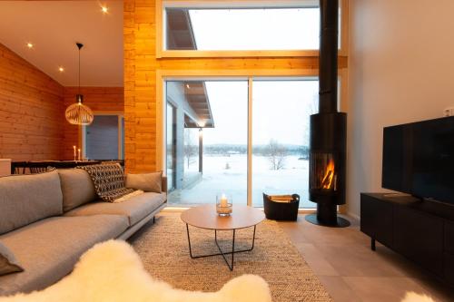 a living room with a couch and a fireplace at Riverside luxury suites in Rovaniemi
