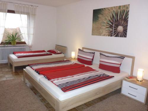 1 dormitorio con 2 camas con sábanas rojas en Ferienwohnung Weyl, en Eschbach