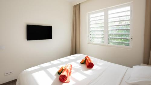 ein weißes Schlafzimmer mit zwei Hot Dogs auf einem Bett in der Unterkunft Ultimate Caribbean Experience in Willemstad