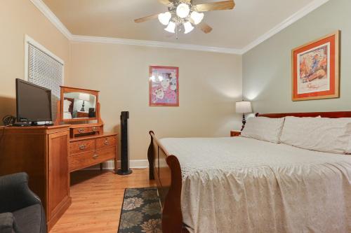 a bedroom with a bed and a flat screen tv at Grenoble House in New Orleans