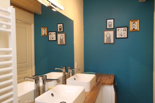 un bagno con due lavandini e una parete blu di Le Grenier du 11 a Gérardmer