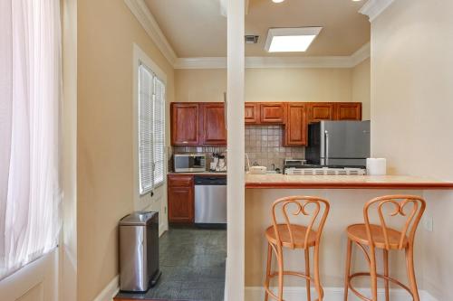a kitchen with two bar stools and a counter at Grenoble House in New Orleans