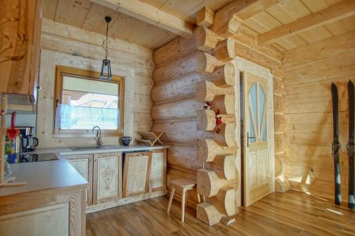 uma cozinha num chalé de madeira com um lavatório e uma janela em Apartament z widokiem w Murzasichlu em Murzasichle