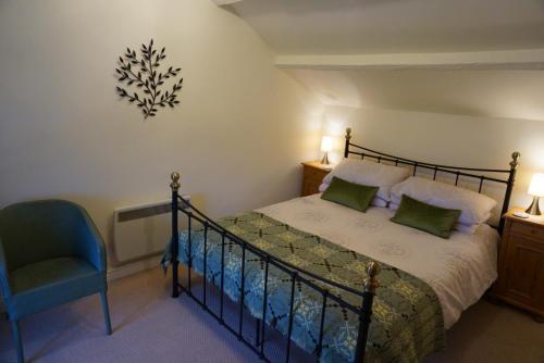 DwyranにあるWhite Lilac Cottageのベッドルーム1室(ベッド1台、青い椅子付)