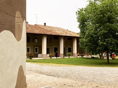 a building with a tree in front of it at B&B Cascina Sagrestia in Asola