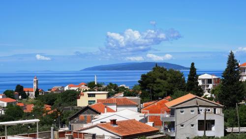a city with houses and the ocean in the background at Apartments Mateljak in Gradac