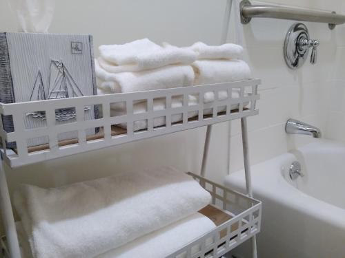 a white bathroom with a rack of towels at The Inn on Mount Desert in Bar Harbor