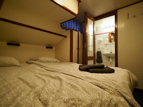 a bedroom with a large white bed with a mirror at Hotelboot Sarah in Amsterdam