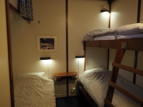 a room with two bunk beds and a table at Hotelboat Sarah in Amsterdam