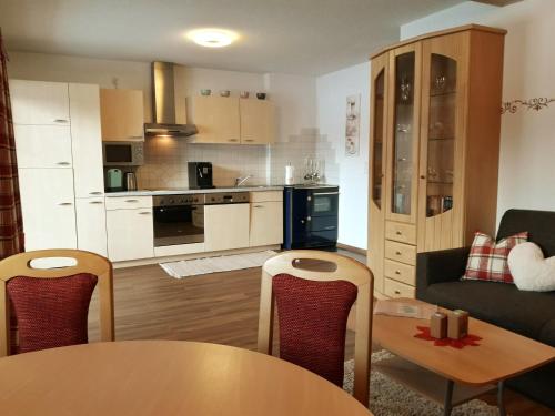 a kitchen and living room with a table and a couch at Haus Gaby in Holzgau