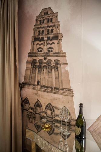 a picture of a tower with wine glasses on a table at Guest House Imperial in Split