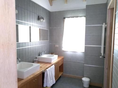 a bathroom with two sinks and a mirror at Villa Gutierrez Braun in San Martín de los Andes