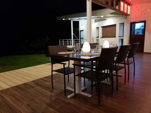 a dining room table with chairs and wine glasses at Hotel Laguna Arenal in Unión