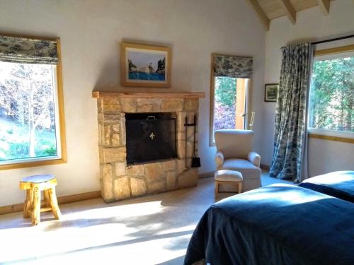 a bedroom with a stone fireplace and a bed at Villa Gutierrez Braun in San Martín de los Andes
