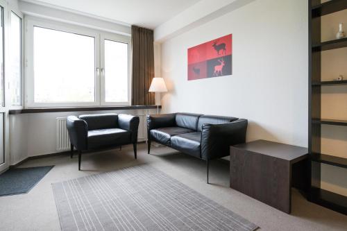 a living room with a couch and a chair at Waldhof Residenz in Offenbach