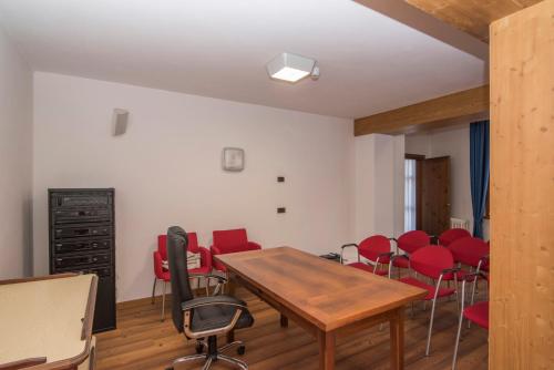 a conference room with red chairs and a wooden table at Al Sole Hotel Ristorante dal 1870 in Pieve di Cadore