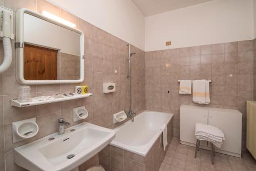 bagno con lavandino e specchio di Al Sole Hotel Ristorante dal 1870 a Pieve di Cadore