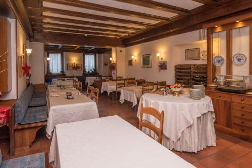 a restaurant with tables with white tablecloths at Al Sole Hotel Ristorante dal 1870 in Pieve di Cadore