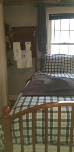 two beds in a bedroom with towels hanging on the wall at Hallowell Rooming House in Hallowell