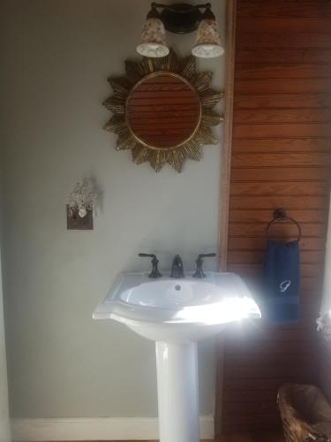 a bathroom with a sink and a mirror on the wall at Hallowell Rooming House in Hallowell