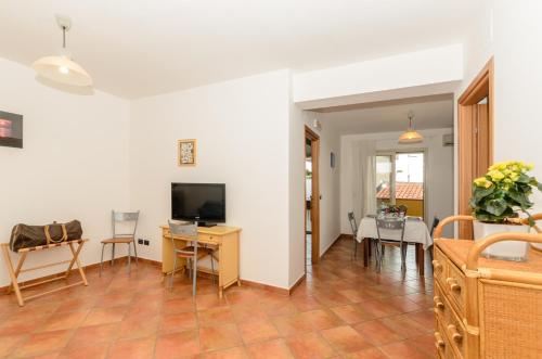 a living room with a television and a table and chairs at Le Tartarughe Aparthotel in Letojanni