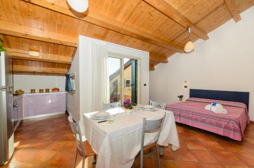 a dining room with a table and a bed at Le Tartarughe Aparthotel in Letojanni