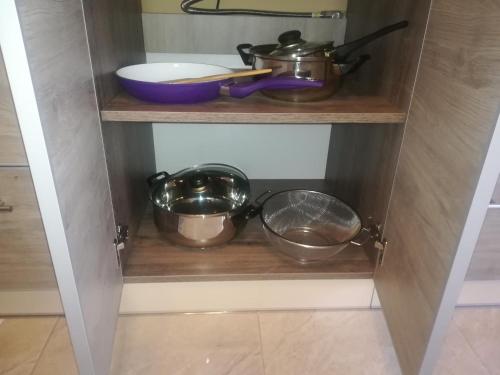 a cupboard with some pots and pans in it at Zlata De Luxe in Ivano-Frankivsk