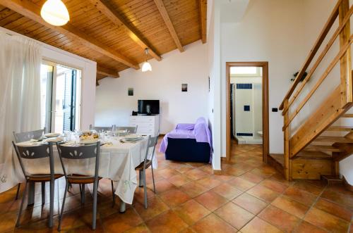 a dining room with a white table and chairs at Le Tartarughe Aparthotel in Letojanni