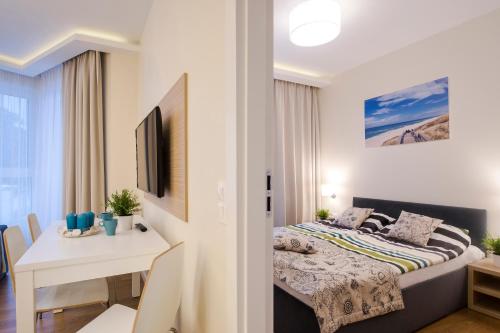 a bedroom with a bed and a desk in a room at Apartament DeLux Marina in Kąty Rybackie