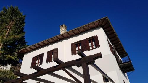 a white building with windows on top of it at Archontiko Mansion Porteli Αρχοντικο Πορτελι in Makrinítsa