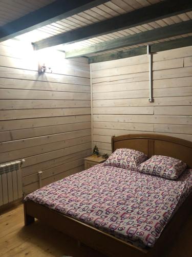 a bedroom with a bed in a room with wooden walls at RIVIERA in Lekechi