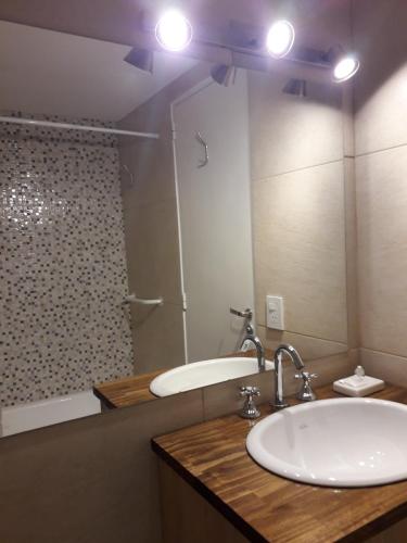 un bagno con un lavandino, una vasca e uno specchio di Patagonia Suite a San Carlos de Bariloche