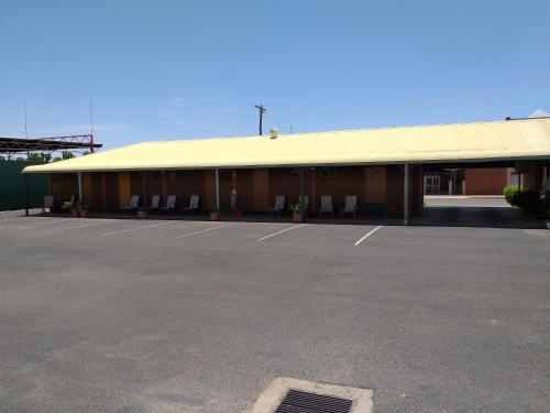 a building with a parking lot in front of it at Country Mile Motor Inn in Forbes