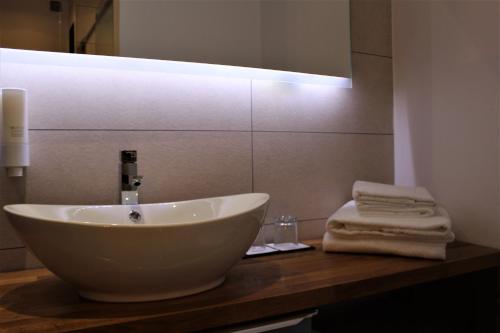 a bathroom with a sink and a mirror and towels at RIOSHOUSE Henley in Henley on Thames