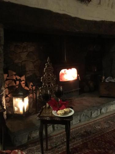 a table with a plate of food and a christmas tree in a fireplace at Great House Guest House in Llantwit Major