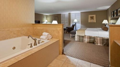 a hotel room with a tub and a bed at Best Western Plus York Hotel and Conference Center in York